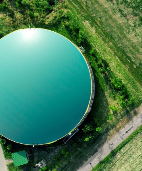 Aerial view of a biogas plant surrounded by greenery.